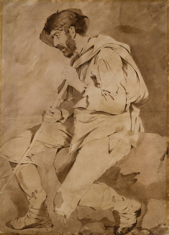 A drawing of a man, The Tramp, seated on a rock, facing left, leaning on a staff. He is bearded and wears a hat. His clothes appear dishevelled, his knee-breeches are are torn and stained in places and buttons are missing. A cloak, or soft cloth bag, has been thrown over his shoulder. He is wearing shoes and what appear to be gaiters or some sort of leg covering, bound around his lower legs with string. Alternatively, these may be a kind of low shoe that is secured to the foot and ankle by way of long ties. Drawn by Joseph Wright of Derby (1734-1797), c.1774. Pen, ink and sepia wash on paper. Displayed in a cream window mount.
