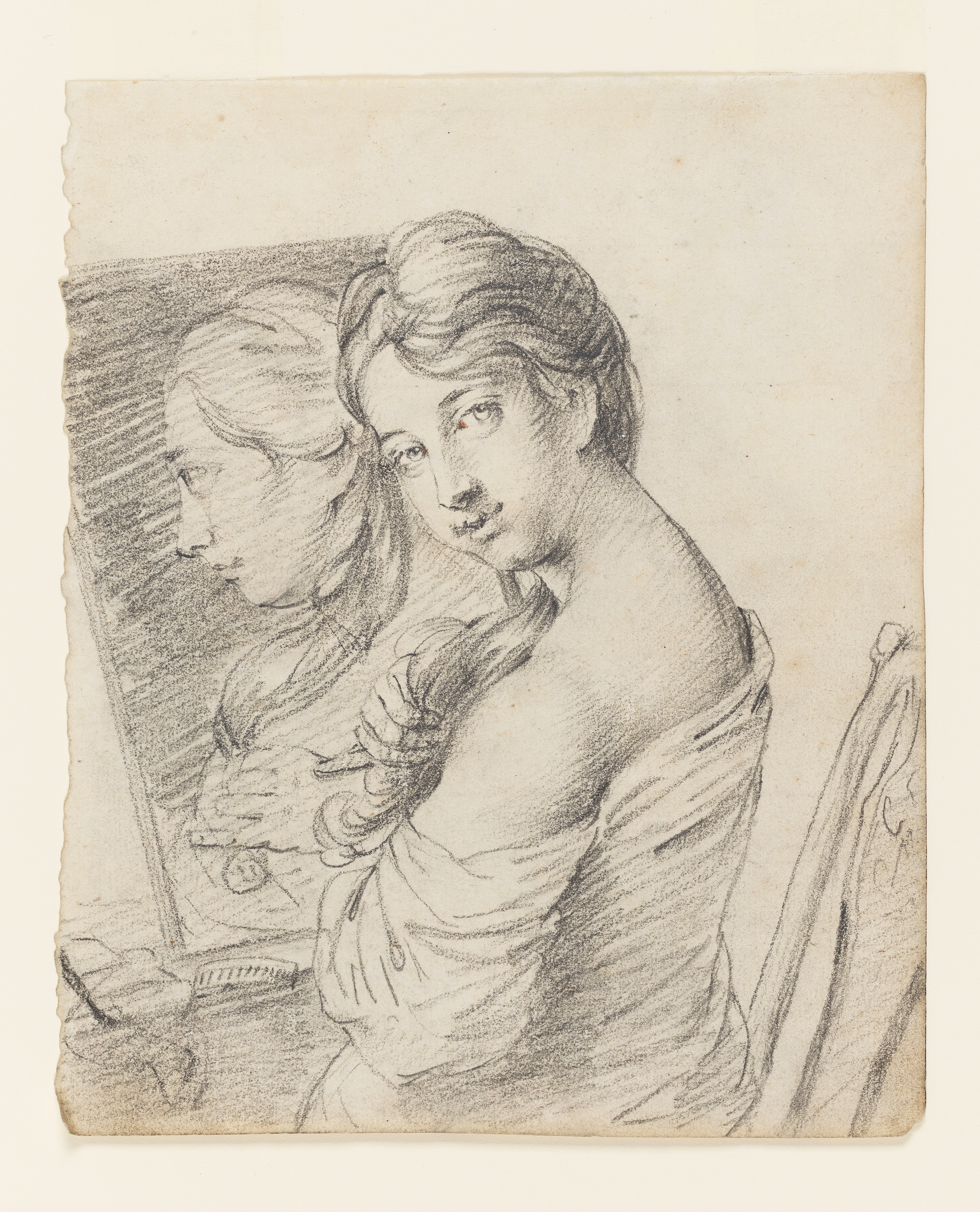 Drawing of a young woman seated at a mirror. She turns to face the viewer over her left shoulder and plays with a lock of her hair. Her clothing is loose and has fallen below her shoulders. A hair comb sits on the table in front of her. The mirror captures her reflection. On the verso is a pencil drawing of a man with a book. Made by Joseph Wright of Derby (1734 - 1797), c. 1750. Pencil on paper. Displayed in a cream window mount.