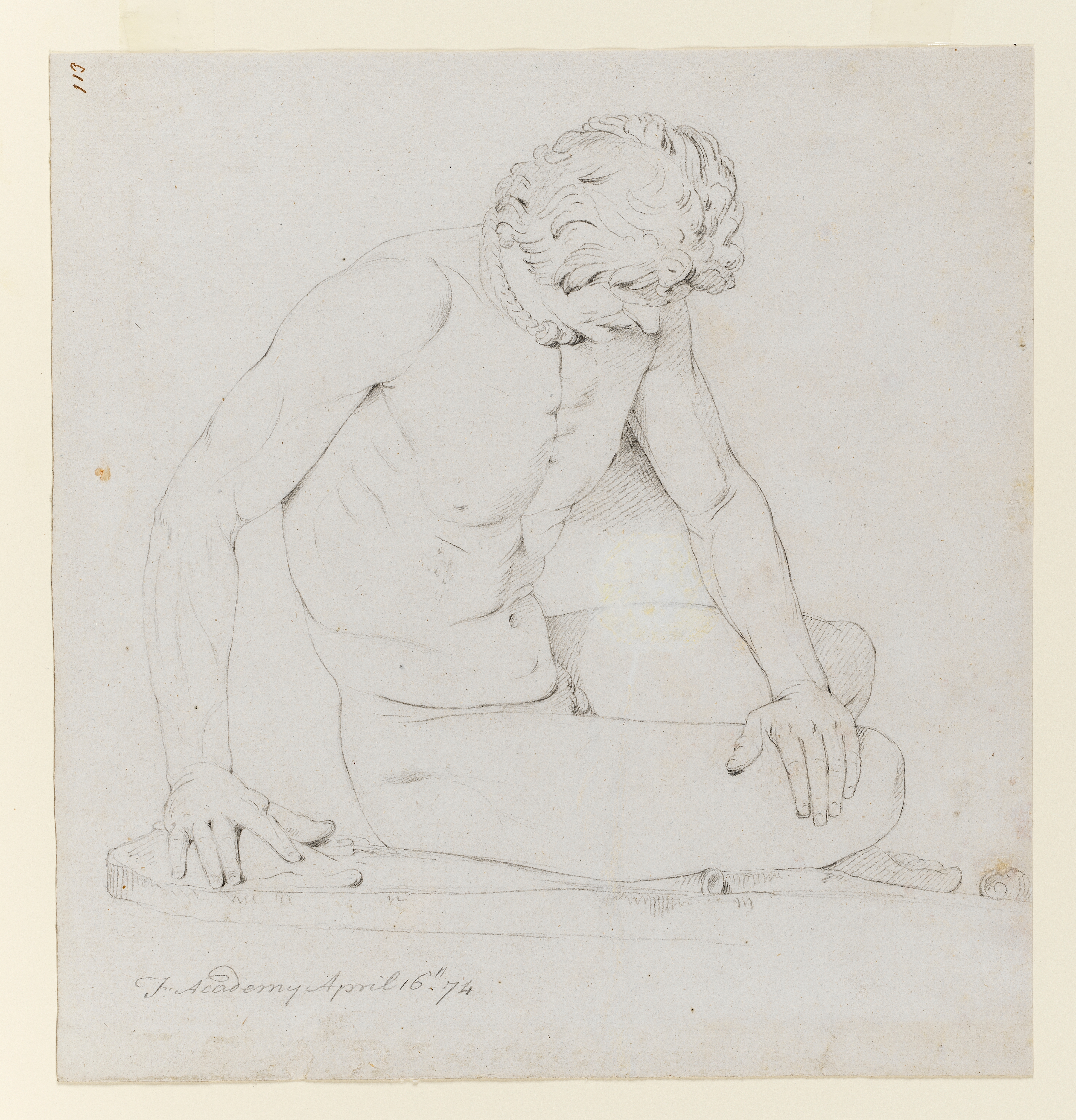 Drawing of nude male figure seated, identified as a study of the cast of the Roman sculpture (itself a copy of a lost Hellenistic bronze sculpture) called the 'Dying Gaul'. The figure is seated on the ground in a semi-recumbent position, turned slightly towards the right. He wears a torque around his neck. His head is bowed and he rests his left hand on his leg; his right hand resting on a rock for support. Inscribed on recto, to top left (handwritten in ink): '113' and to lower left (handwritten in pencil): 'F. Academy April 16th. 74'. Made by Joseph Wright of Derby (1734 - 1797), 1774. Pencil and charcoal on white laid paper. Displayed in a cream window mount.