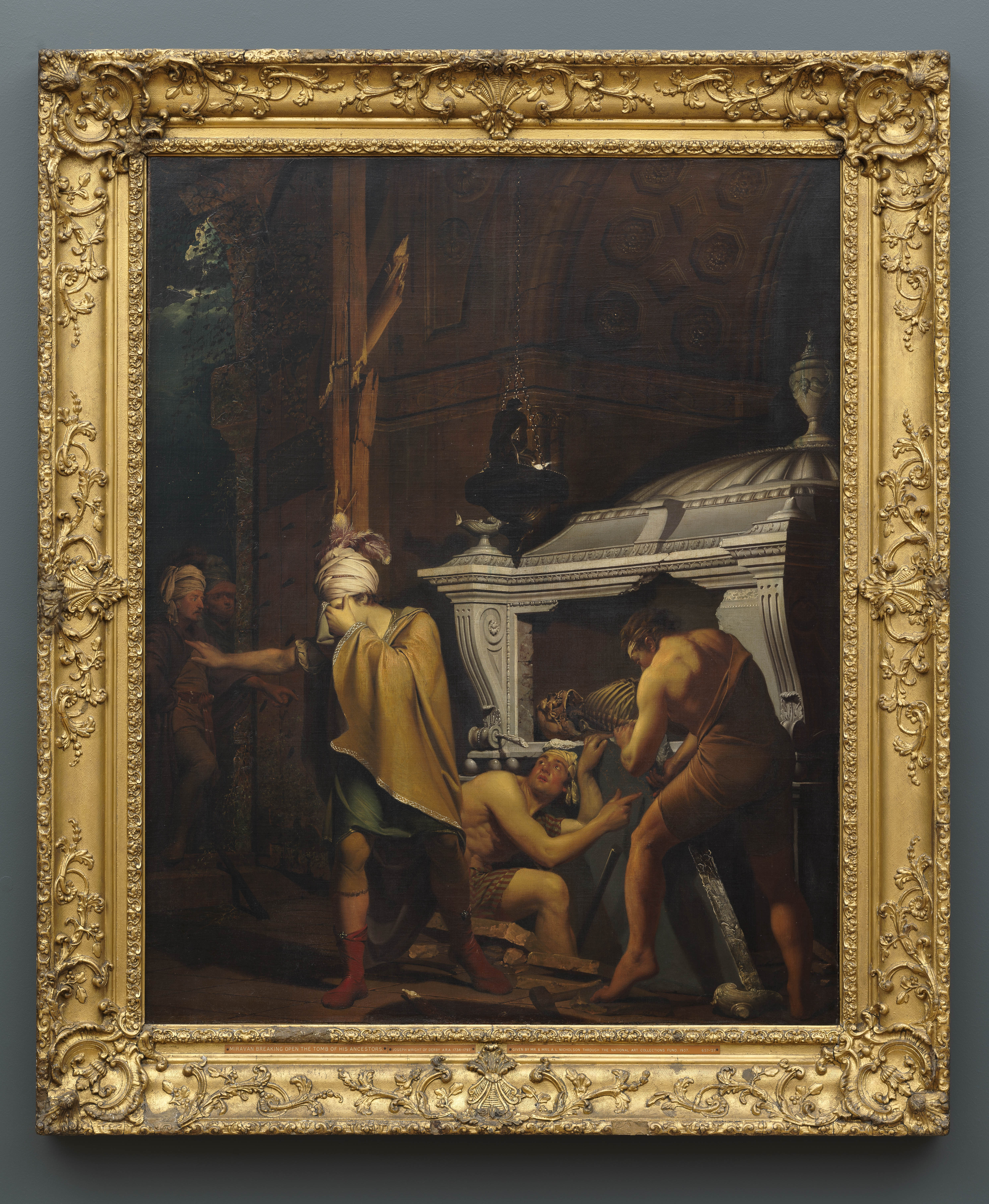 Painting of three male figures, breaking into a lamp lit tomb, by night. The figure to the left, a nobleman called Miravan, is richly dressed, and turns away in horror as one of his companions points to a Persian inscription on the tomb slab. Through a doorway on the far left hand side of the canvas, two further male figures peer in. Inscribed in the lower right hand corner along the edge of a stone slab 'I. WRIGHT Pxt. / 1772'. Painted by Joseph Wright of Derby (1734 - 1797). Oil on canvas in gilded frame.