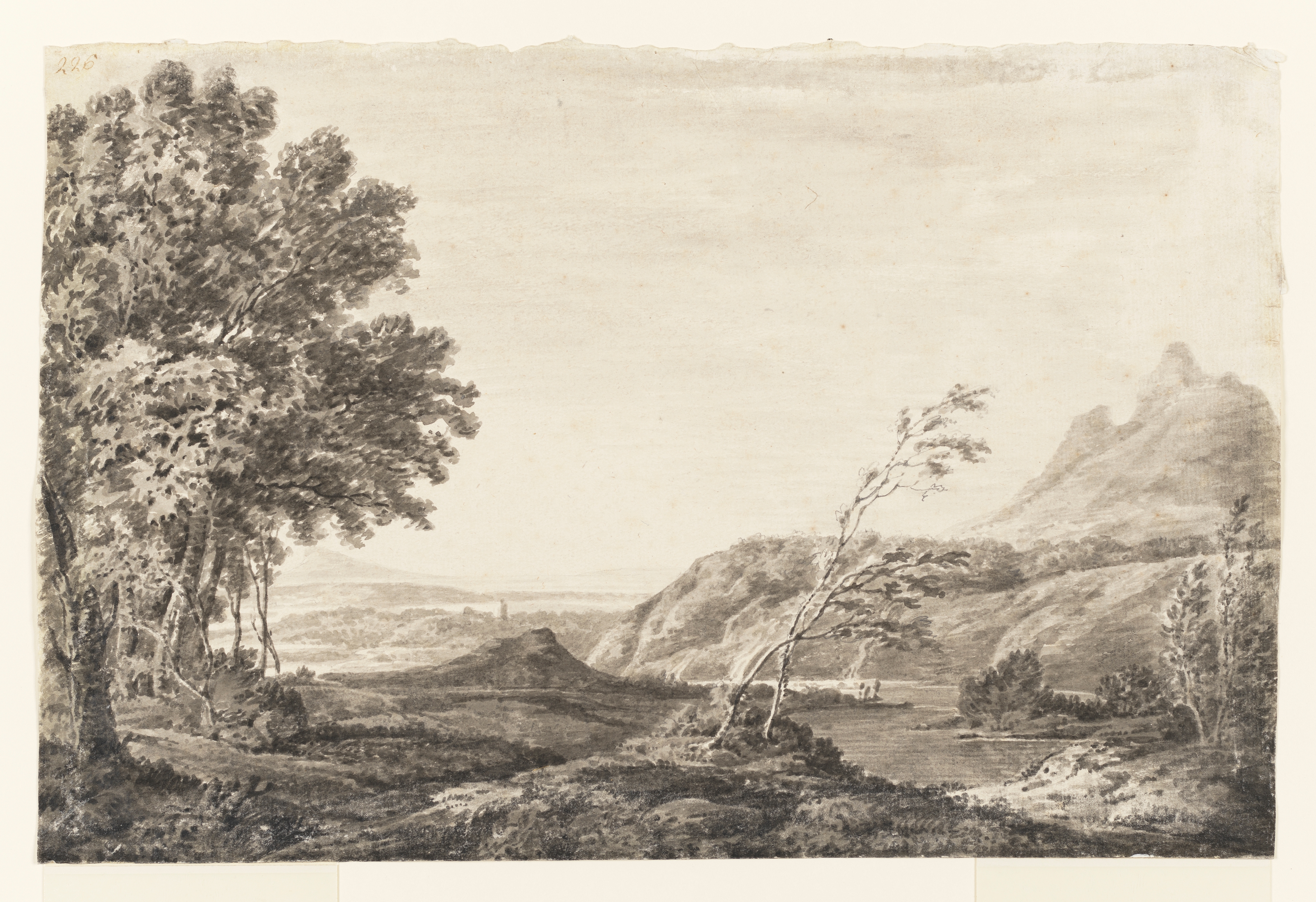 Drawing of a landscape, featuring a river and hills. To the left is a clump of mature trees; to right of centre a young tree leans to the right. A tall building or monument can be glmpsed in the distance. Inscribed to recto, top left corner (handwritten in ink): '226'. Made by Joseph Wright of Derby (1734 - 1797), c.1774-5, pencil and ink wash on paper.