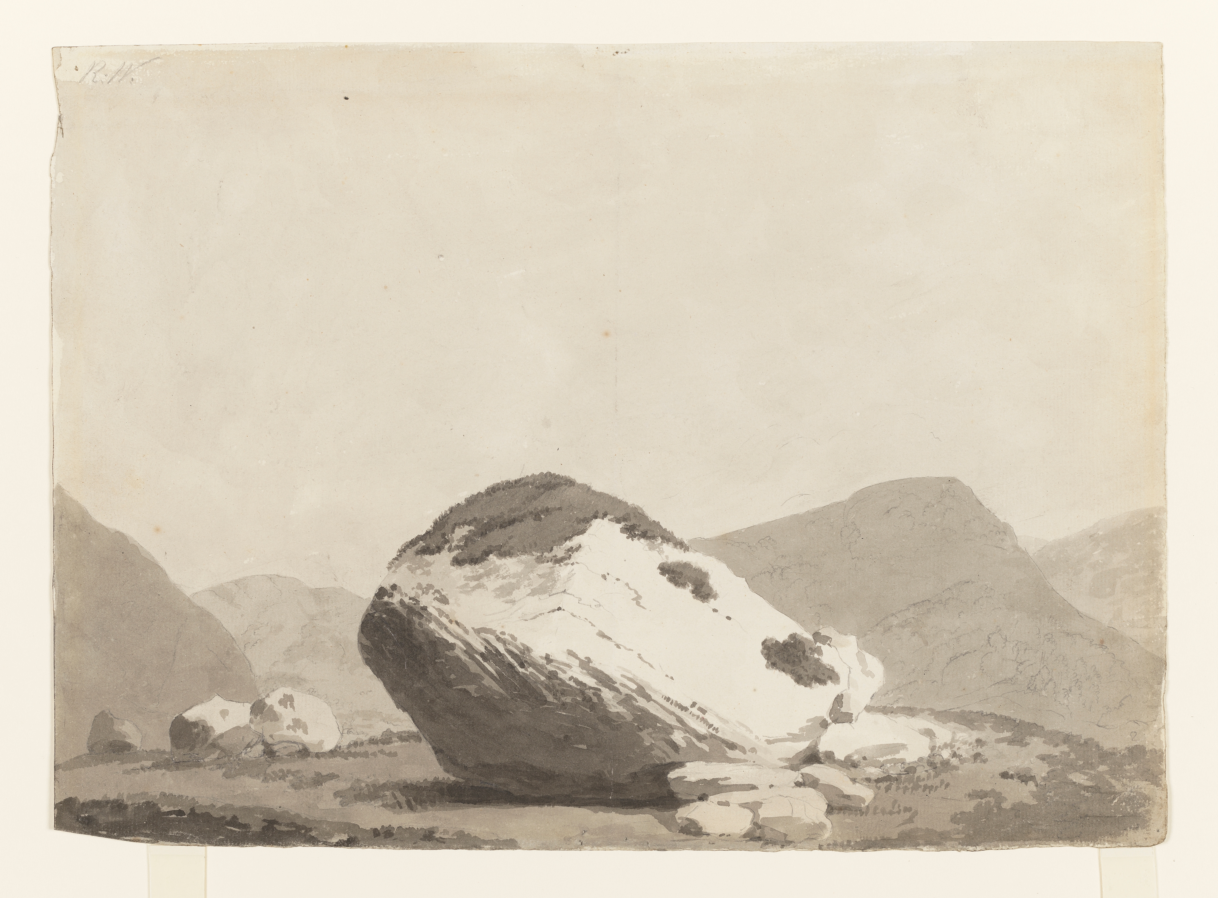 Drawing of a mountainous landscape featuring a large boulder, identified as the Bowder Stone in Borrowdale in the Lake District. Inscribed on recto, top left (handwritten in pencil): 'R.W'. Made by Joseph Wright of Derby (1734-1797), c.1794. Ink wash over pencil on white laid paper.