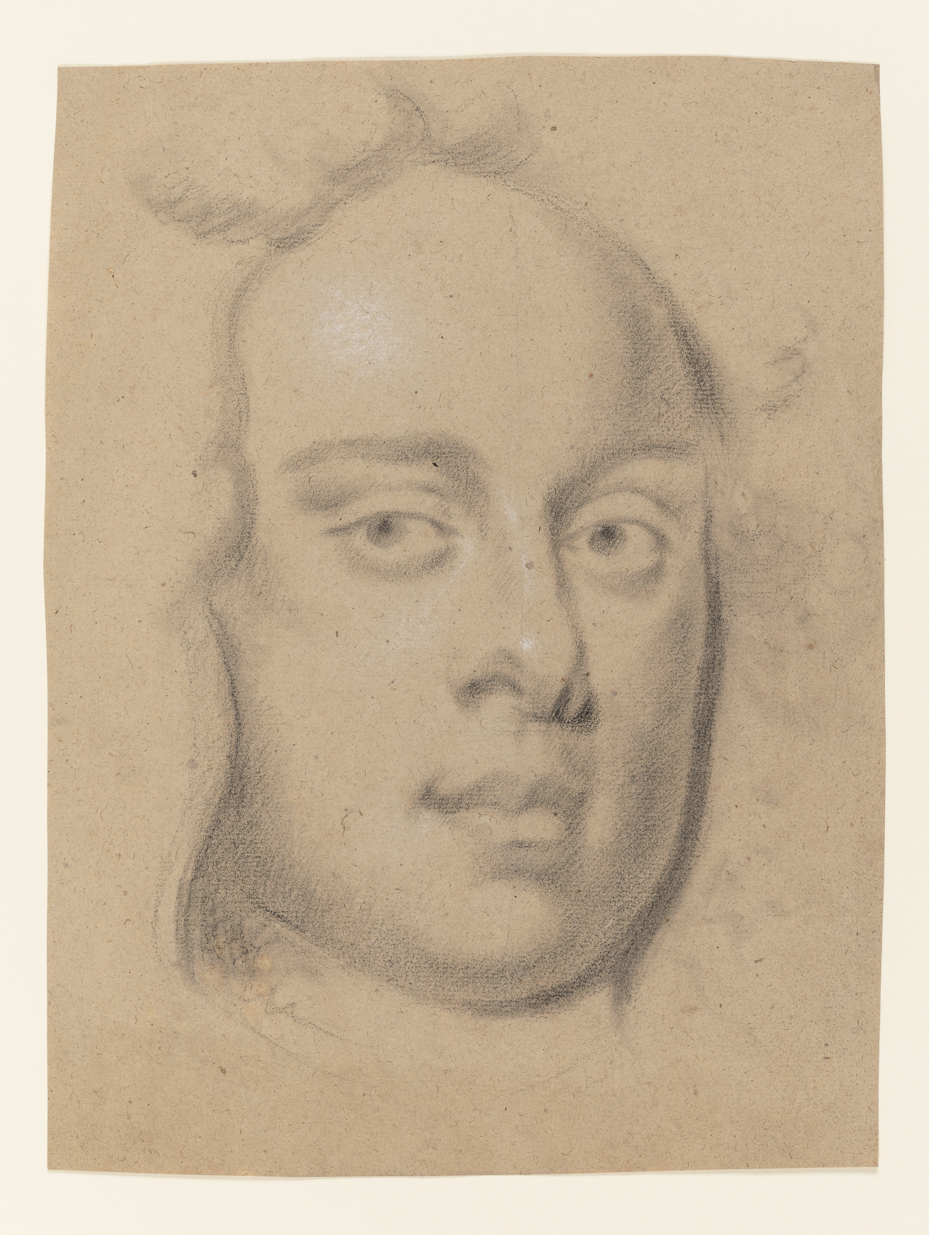 Study of a young man's head, facing slightly right, the outline of his hair or wig framing his face. Light glints from the left side of his forehead and the end of his nose. Made by Joseph Wright of Derby (1734 - 1797). Black and white chalk on buff coloured paper, in cream window mount.