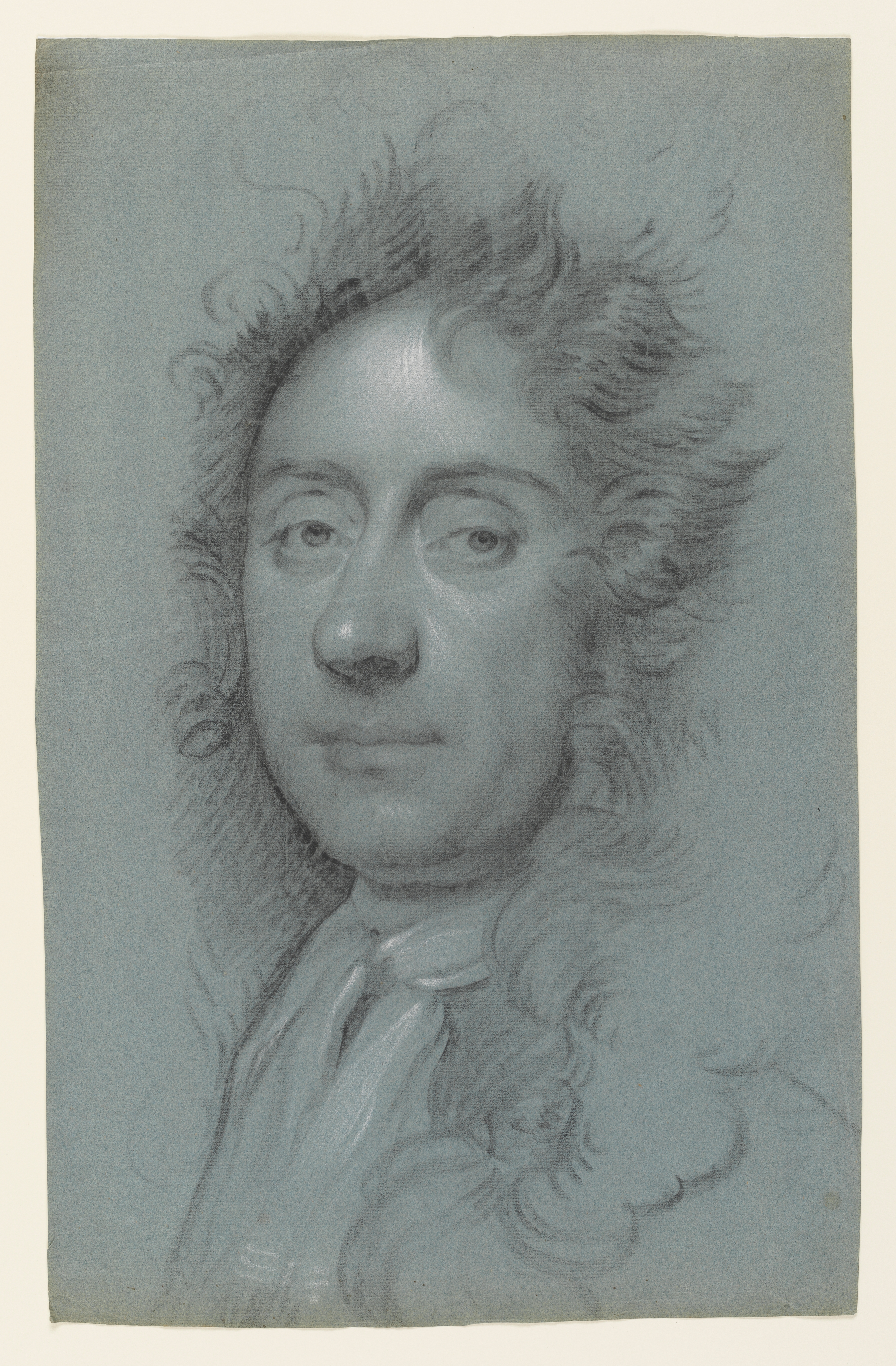 Study of a man, head and shoulders only, facing left. He wears a neck stock, with a horizontal stripe running through it, and his hair or wig is curled and hangs loosely, below his shoulders. A horizontal fold line runs across the sheet and the centre of the subject's face. Made by Joseph Wright of Derby (1734 - 1797). Black and white chalk on blue paper, in cream window mount.