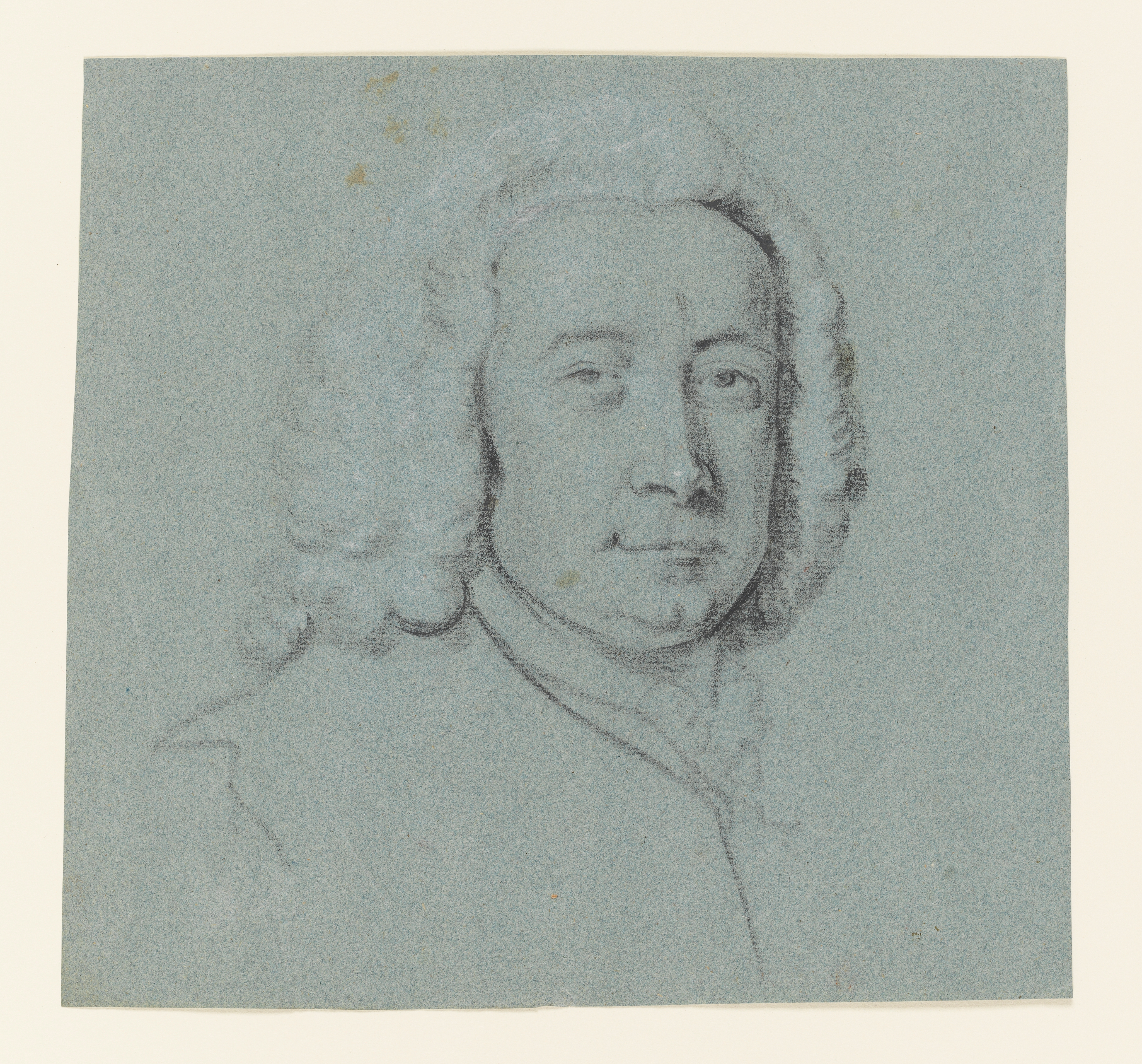Study of a man, head and shoulders only, facing slightly to the right. He wears a wig (?) and a coat with a neck cloth and possibly a jabot beneath. Made by Joseph Wright of Derby (1734 - 1797). Black and white chalk on blue paper, in cream window mount.